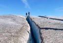 Photo of Two people walking on top Exit glacier